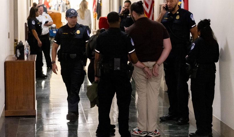 Capitol Police officers arrest a protester after a complaint from US Republican Representative from New York George Santos at the Longworth House Office Building on Capitol Hill in Washington, DC, on October 13, 2023. (Photo by Julia Nikhinson / AFP) (Photo by JULIA NIKHINSON/AFP via Getty Images)