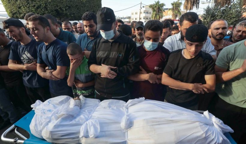 People mourn by the body of Hamas commander Ayman Nofal during his funeral in the Bureij camp for Palestinian refugees in the central Gaza Strip, on October 17, 2023. "Ayman Nofal, 'Abu Ahmad', a member of the general military council and commander of the central command in Al-Qassam Brigades, was killed" in an Israeli strike on the central Gaza Strip, Hamas said in a statement on October 17, referring to its military wing. (Photo by Bashar TALEB / AFP) (Photo by BASHAR TALEB/AFP via Getty Images)