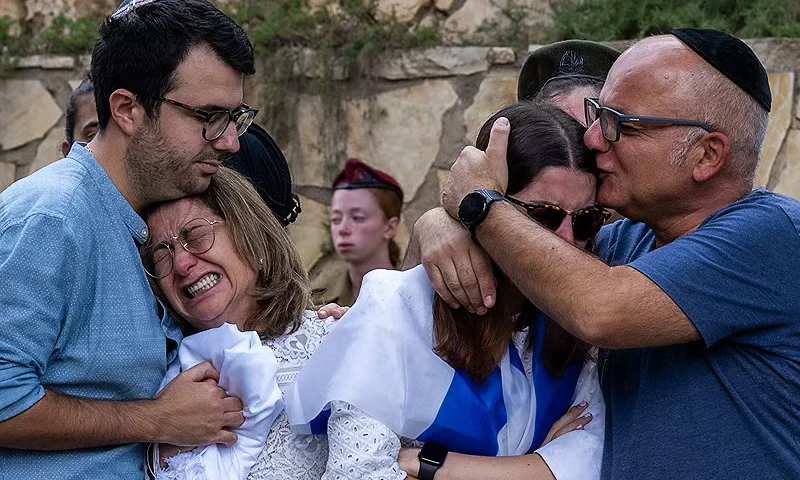 JERUSALEM, ISRAEL - OCTOBER 12: The mother (L), sister (R) and immediate family of Valentin (Eli) Ghnassia, 23, who was killed in a battle with Hamas militants at Kibbutz Be’eeri near the Israeli border with the Gaza Strip, react during his funeral ceremony on October 12, 2023 at Mount Herzl Military Cemetery in Jerusalem, Israel. Israel has sealed off Gaza and launched sustained retaliatory air strikes, which have killed at least 1,200 people with more than 300, 000 displaced, after a large-scale attack by Hamas. On October 7, the Palestinian militant group Hamas launched a surprise attack on Israel from Gaza by land, sea, and air, killing over 1,200 people and wounding around 2800. Israeli soldiers and civilians have also been taken hostage by Hamas and moved into Gaza. The attack prompted a declaration of war by Israeli Prime Minister Benjamin Netanyahu. (Photo by Alexi J. Rosenfeld/Getty Images)
