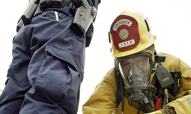 LOS ANGELES - AUGUST 5: A firefighter checks an officer for radiation at the scene of the mock explosion of a "dirty bomb" during a simulated attack at a dock at the Port of Los Angeles on August 5, 2004 in Los Angeles, California. In the drill's scenario, a "dirty bomb" smuggled into the port in a shipping container exploded as a bus was driving by, releasing a plume of radioactivity. More than 850 civilian and military personnel representing more than 60 government agencies, community based and private-sector organizations are participating in the terror response drill, "Determined Promise 2004". (Photo by David McNew/Getty Images)