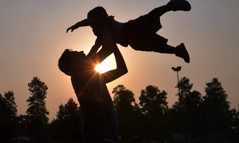 Indian father Shailesh throws up his son, Harish, at a park in Amritsar on June 19, 2016, on Father's Day, a day observed in many countries to celebrate fathers and fatherhood. / AFP / NARINDER NANU (Photo credit should read NARINDER NANU/AFP via Getty Images)