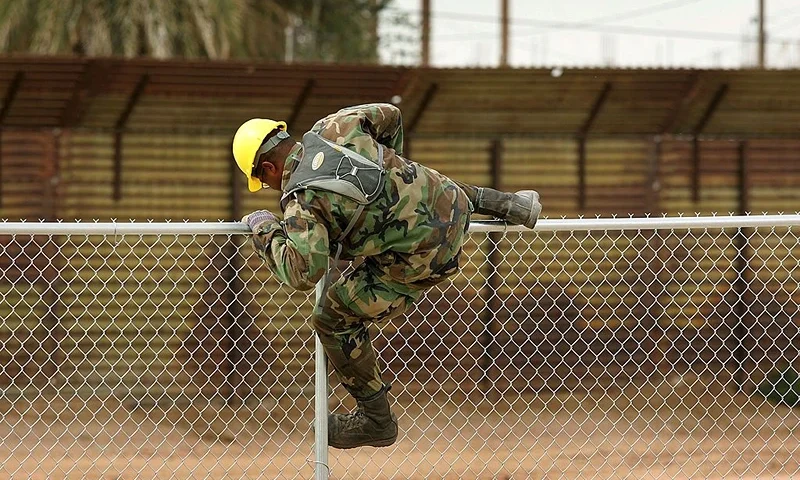 YUMA, AZ - MARCH 16: A U.S. Army Ranger climbs over a chain-link fence that will be topped with barbed wire as his unit finishes building it parallel to the primary steel U.S./Mexico border fence (background) to further fortify the border against people crossing illegally into the U.S. from Mexico on March 16, 2006 near the border town of near San Luis, south of Yuma, Arizona. As Congress begins a new battle over immigration policy, U.S. Customs and Border Protection (CBP) border patrol agents in Arizona are struggling to control undocumented immigrants that were pushed into the region by the 1990's border crack-down in California called Operation Gatekeeper. A recent study by the Pew Hispanic Center, using Census Bureau data, estimates that the U.S. currently has an illegal immigrant population of 11.5 million to 12 million, about one-third of them arriving within the past 10 years. More than half are reportedly from Mexico. Ironically, beefed-up border patrols and increased security are reportedly having the unintended result of deterring many from returning to their country of origin. (Photo by David McNew/Getty Images)