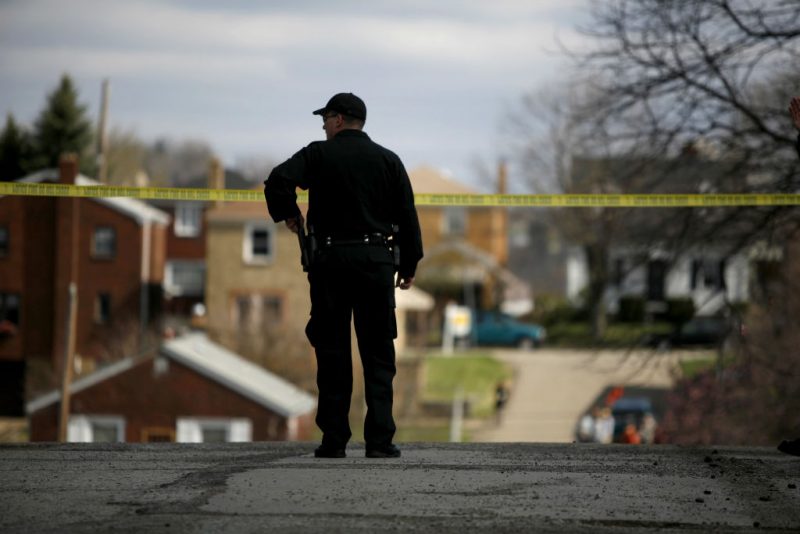 PITTSBURGH - APRIL 4: A police officer watches over the crime scene from a nearby corner April 4, 2009 in Pittsburgh, Pennsylvania. Five police officers were shot during a standoff with a suspect in the Stanton Heights neighborhood of Pittsburgh, after police responded to a domestic dispute. (Photo by Ross Mantle/Getty Images)