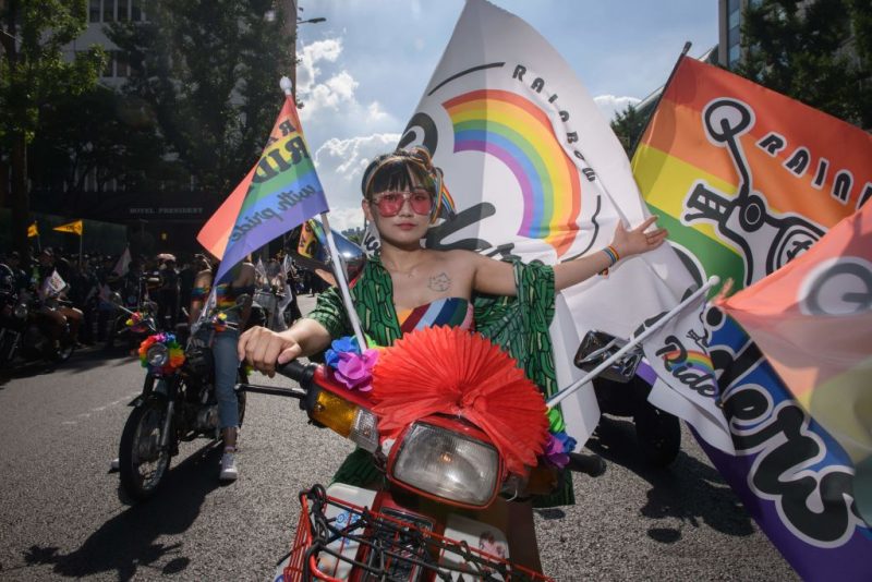 A participant of the Seoul Queer Parade waits on a motorcycle for the start of the parade on a street in Seoul on July 14, 2018. - Tens of thousands of members of the LGBT community and gay rights supporters paraded through Seoul's city centre on July 14 as conservatives protested loudly at what they called 