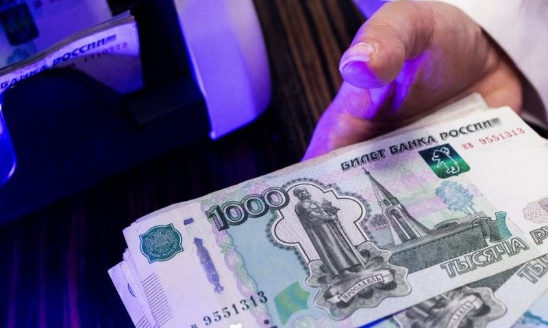 An employee holds Russian 1000-rouble banknotes next to a currency counting machine in a bank office in Moscow, Russia, in this illustration picture taken October 9, 2023. REUTERS/Maxim Shemetov/Illustration