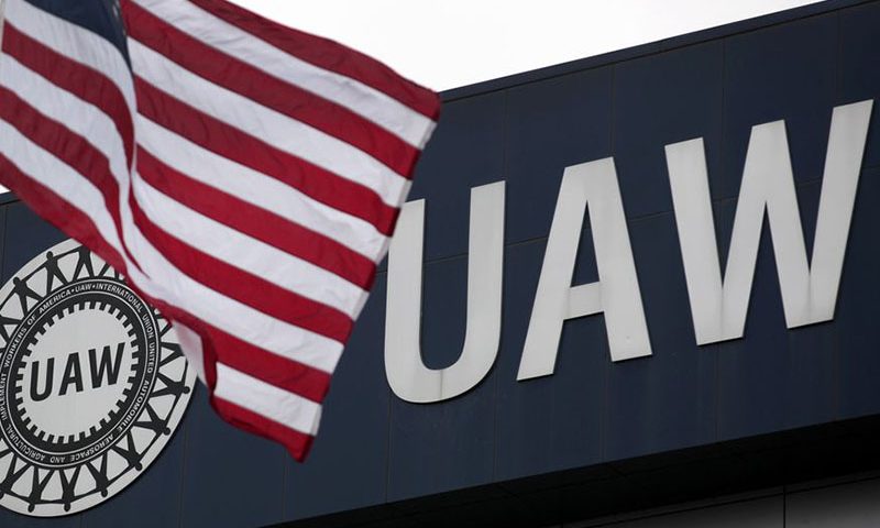 An American flag flies in front of the United Auto Workers union logo on the front of the UAW Solidarity House in Detroit, Michigan, September 8, 2011. Picture taken September 8, 2011. To match Special Report USA-AUTOS/UNION REUTERS/Rebecca Cook (UNITED STATES - Tags: BUSINESS EMPLOYMENT TRANSPORT)