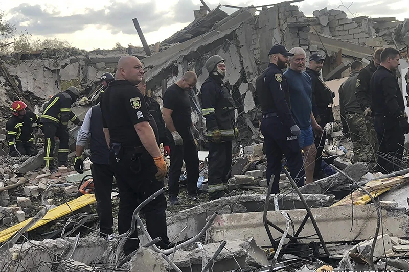 In this photo provided by the Ukrainian Police Press Office, emergency workers search the victims of the deadly Russian rocket attack that killed more than 40 people in the village of Hroza near Kharkiv, Ukraine, Thursday, Oct. 5, 2023. (Ukrainian Police Press Office via AP)