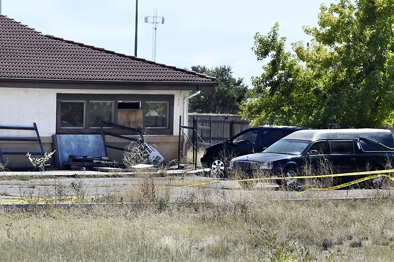 A hearse and debris can be seen at the rear of the Return to Nature Funeral Home in Penrose, Colo. Thursday, Oct. 5, 2023. Authorities said Thursday they were investigating the improper storage of human remains at a southern Colorado funeral home that performs 