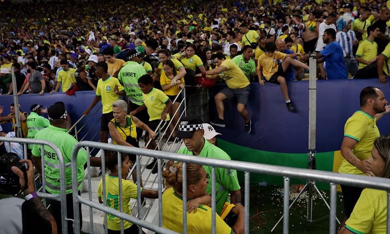 Fans clash with security staff in the stands causing a delay to the start of the match REUTERS/Ricardo Moraes
