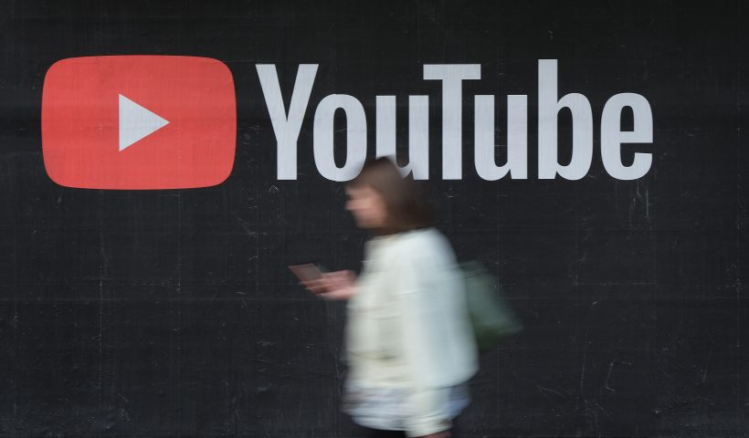 BERLIN, GERMANY - SEPTEMBER 27: A young woman with a smartphone walks past a billboard advertisement for YouTube on September 27, 2019 in Berlin, Germany. YouTube has evolved as the world's largest platform for sharing video clips. (Photo by Sean Gallup/Getty Images)