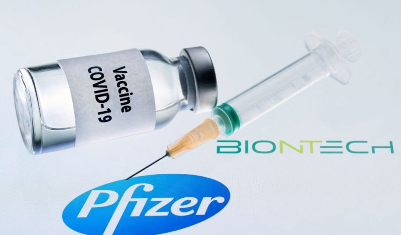 This illustration picture taken on November 23, 2020 shows a bottle reading "Vaccine Covid-19" and a syringe next to the Pfizer and Biontech logo. - The European Commission has signed five contracts to pre-order vaccines, among which with the U.S.-German company Pfizer-BioNTech (up to 300 million doses). (Photo by JOEL SAGET / AFP) (Photo by JOEL SAGET/AFP via Getty Images)