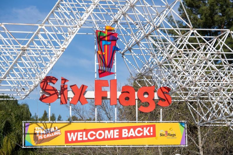 A sign at the entrance of the theme park Six Flags Magic Mountain welcomes the public back on the day of the park's re-opening, April 1, 2021, in Valencia, California. - Six Flags Magic Mountain is the first theme park to re-open in Los Angeles County after closures amid the coronavirus pandemic. (Photo by VALERIE MACON / AFP) (Photo by VALERIE MACON/AFP via Getty Images)