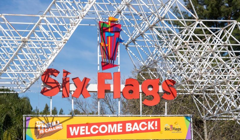 A sign at the entrance of the theme park Six Flags Magic Mountain welcomes the public back on the day of the park's re-opening, April 1, 2021, in Valencia, California. - Six Flags Magic Mountain is the first theme park to re-open in Los Angeles County after closures amid the coronavirus pandemic. (Photo by VALERIE MACON / AFP) (Photo by VALERIE MACON/AFP via Getty Images)