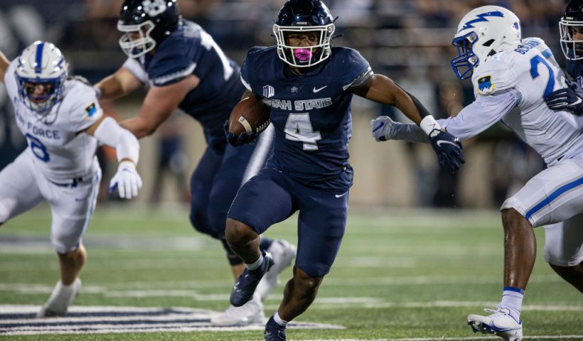 LOGAN, UT- OCTOBER 8: Calvin Tyler Jr., #4 of the Utah State Aggies rushes the ball against TD Blackmon #27 and Bo Richter #8 of the Air Force Falcons during the second half of their game October 8, 2022 Maverik Stadium in Logan, Utah. (Photo by Chris Gardner/ Getty Images)