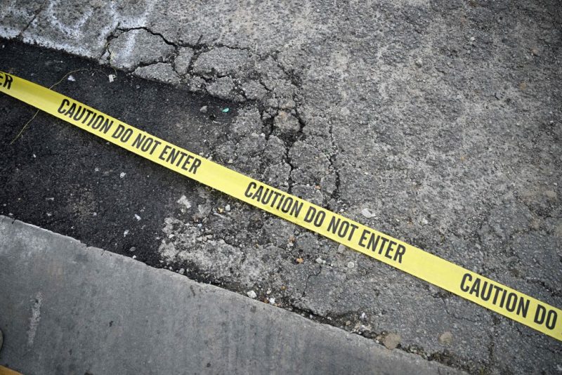 TOPSHOT - Police tape is seen on the ground at the scene of a mass shooting in Monterey Park, California, on January 22, 2023. - Ten people have died and at least 10 others have been wounded in a mass shooting in a largely Asian city in southern California, police said, with the suspect still at large hours later. (Photo by Robyn BECK / AFP) (Photo by ROBYN BECK/AFP via Getty Images)