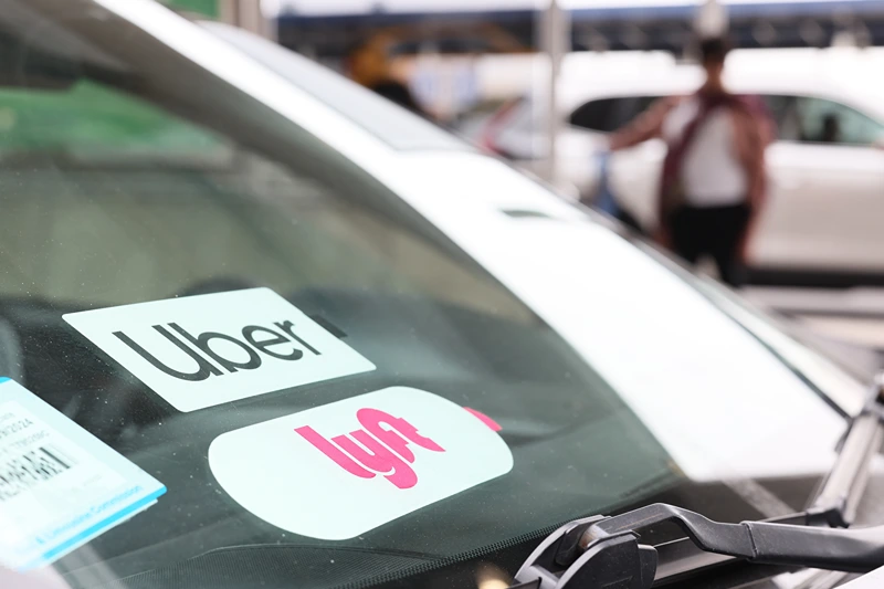 Ride-Hailing App Lyft Confirms Its Cutting Roughly A Quarter Of Its Workforce
NEW YORK, NEW YORK - APRIL 28: A Lyft decal is seen on a car in the pick-up area at JFK Airport on April 28, 2023 in New York City. Lyft, the ride-hailing app, confirmed that it will be laying off 1,072 employees, which equals to roughly 26% of its corporate workforce. The layoffs were announced last week but no official number was confirmed. (Photo by Michael M. Santiago/Getty Images)