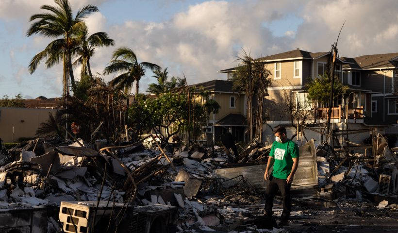 TOPSHOT - A Mercy Worldwide volunteer makes damage assessment of charred apartment complex in the aftermath of a wildfire in Lahaina, western Maui, Hawaii on August 12, 2023. Hawaii's Attorney General, Anne Lopez, said August 11, she was opening a probe into the handling of devastating wildfires that killed at least 80 people in the state this week, as criticism grows of the official response. The announcement and increased death toll came as residents of Lahaina were allowed back into the town for the first time. (Photo by Yuki IWAMURA / AFP) (Photo by YUKI IWAMURA/AFP via Getty Images)