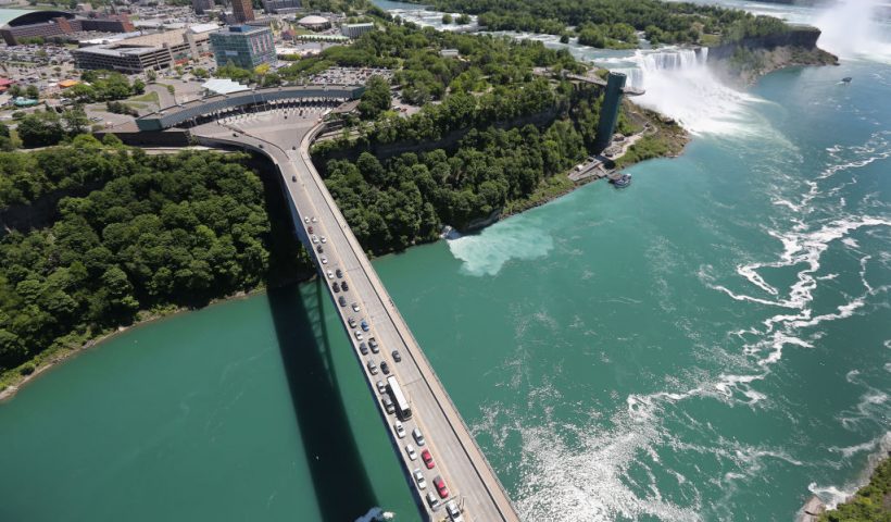 NIAGARA FALLS, NY - JUNE 04: The Rainbow Bridge crosses from the United States (L), into Canada near the Niagara Falls on June 4, 2013 at Niagara Falls, New York. The falls, which have a combined highest flow rate of any waterfall in the world, straddle the U.S.-Canada border, on the Niagara River, which drains Lake Erie into Lake Ontario. The falls, visited by millions of tourists on each side of the border, are also a major source of hydroelectric power for the region. The aerial view was seen from a helicopter flown by the U.S. Office of Air and Marine, (OAM), which monitors and patrols the U.S. northern border with Canada. (Photo by John Moore/Getty Images)