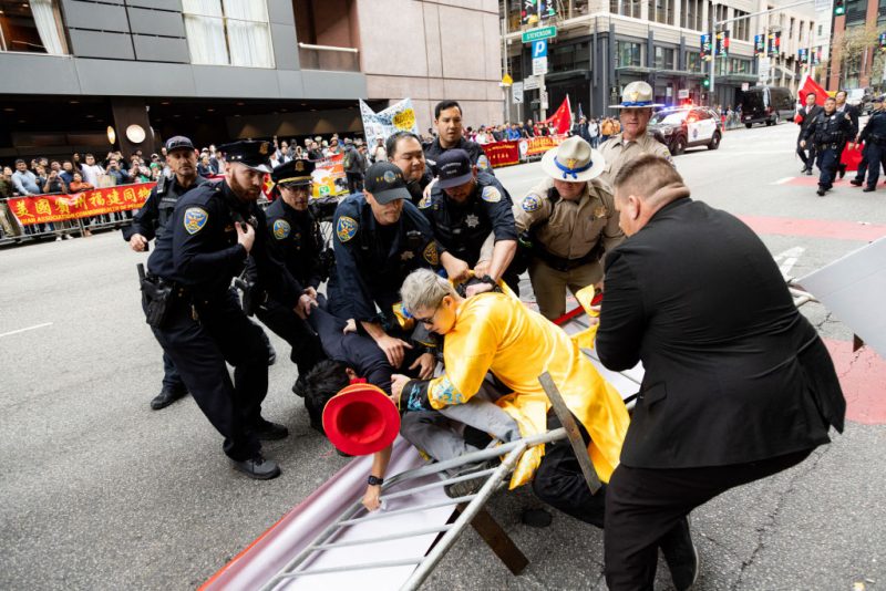 TOPSHOT - Police try to detain a man after skirmishes between anti-Chinese Communist Party protesters and pro-China protesters near the Asia-Pacific Economic Cooperation (APEC) summit in San Francisco, on November 16, 2023. The APEC Summit takes place through November 17. (Photo by Jason Henry / AFP) (Photo by JASON HENRY/AFP via Getty Images)