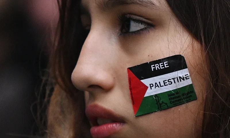 A protester with a Palestinian flag stuck on her cheek takes part in the "Day of Action for Palestine" from Chalk Farm to Camden Town, in London, on November 18, 2023 calling for a ceasefire in the conflict between Israel and Hamas. (Photo by JUSTIN TALLIS / AFP) (Photo by JUSTIN TALLIS/AFP via Getty Images)