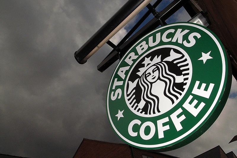 NORTHWICH, UNITED KINGDOM - JULY 03: The Starbucks logo hangs outside one of the company's cafes in Northwich on 3 July, 2008 in Northwich, England. Starbucks Corp in the US recently announced that it plans to close 600 company-operated stores in the country which represent about 7 percent of Starbucks' global workforce. Many UK consumers are beginning to cut back on luxuries as the global credit crunch begins to bite. (Photo by Christopher Furlong/Getty Images)