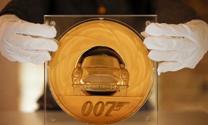 An assistant poses with the James Bond 007 Special Issue 2020 UK Seven-Kilo Gold Proof Coin, the largest coin ever made by The Royal Mint, in London, Britain, March 2, 2020. REUTERS/Henry Nicholls/File Photo