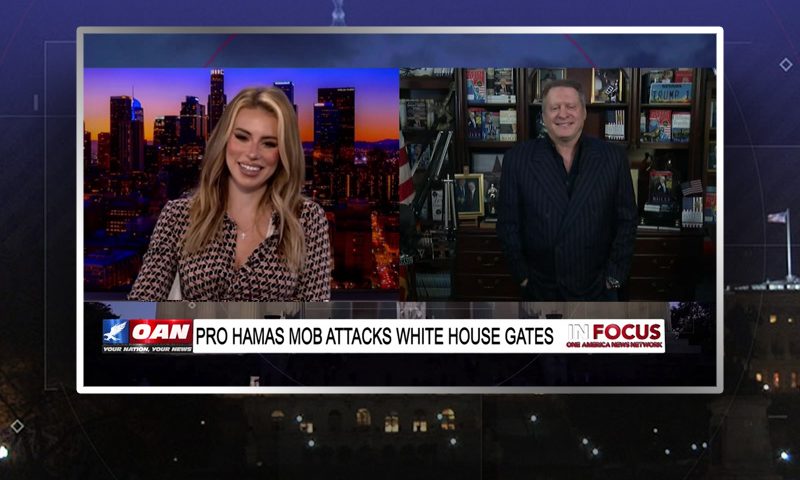 Video still from In Focus on One America News Network showing a split screen of the host on the left side, and on the right side is the guest, Wayne Allyn Root.