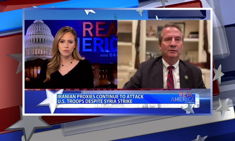 Video still from Real America on One America News Network showing a split screen of the host on the left side, and on the right side is the guest, Tim Burchett.