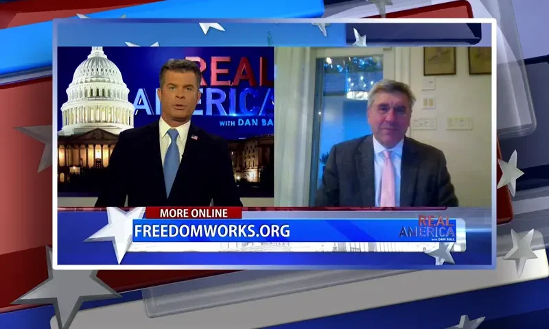 Video still from Real America on One America News Network showing a split screen of the host on the left side, and on the right side is the guest, Steve Moore.