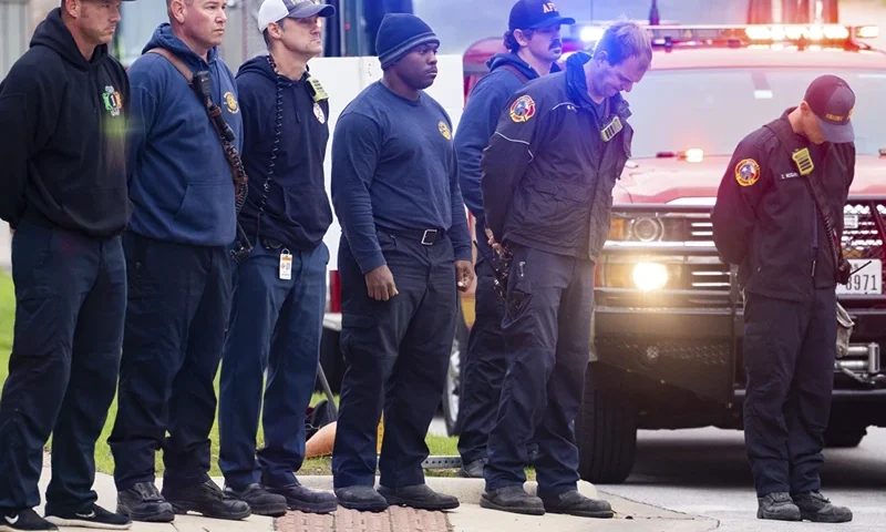 9 | Members of the Austin Fire Department bow their heads as they prepare to drive in a procession leaving Dell Seton Medical Center in Downtown Austin, Texas following the shooting death of a police officer early Saturday, Nov. 11, 2023. A second officer was wounded in the shooting early Saturday that also left the suspected gunman dead, according to a post on the City Council message board by the mayor's chief of staff. (Sara Diggins/Austin American-Statesman via AP)