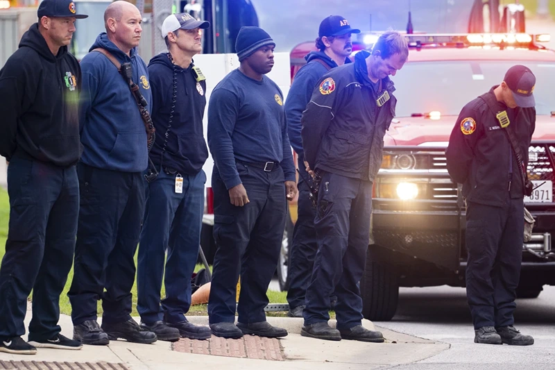 9 | Members of the Austin Fire Department bow their heads as they prepare to drive in a procession leaving Dell Seton Medical Center in Downtown Austin, Texas following the shooting death of a police officer early Saturday, Nov. 11, 2023. A second officer was wounded in the shooting early Saturday that also left the suspected gunman dead, according to a post on the City Council message board by the mayor's chief of staff. (Sara Diggins/Austin American-Statesman via AP)
