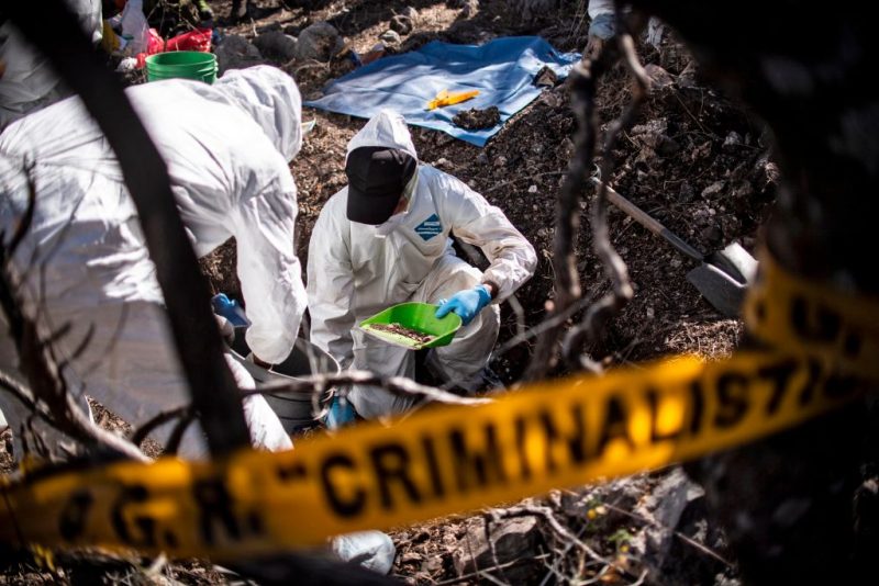 TOPSHOT - Forensic personnel of the Mexican Attorney General work in the exhumation of human remains found during the activities of the fourth National Search Brigade, in Huitzuco de los Figueroa, Guerrero state, Mexico, on January 21, 2019. - More than 40,000 people are missing in Mexico, which has been swept by a wave of violence since declaring war on its powerful drug cartels in 2006. But there is even a more tragic group: some 20 families who have lost children not once but twice, when the ones who remained went looking for their missing siblings and ended up disappearing too. (Photo by Pedro PARDO / AFP) (Photo credit should read PEDRO PARDO/AFP via Getty Images)