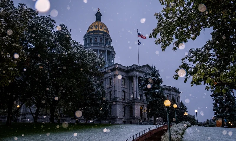TOPSHOT - Snow falls outside the Colorado State Capitol building in Denver, Colorado on September 8, 2020. After a weekend of record-setting heat topping off at 101 degrees Fahrenheit (38.3C), temperatures dropped more than 60 degrees, bringing snow to many parts of the state. Coloradans were ditching the suntan lotion on September 8 and pulling out warm gloves and boots as the western US state went from blazing summer heat to snowfall in just one day. (Photo by Eli IMADALI / AFP) (Photo by ELI IMADALI/AFP via Getty Images)
