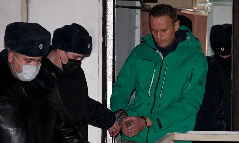 TOPSHOT-RUSSIA-POLITICS-OPPOSITION-NAVALNY TOPSHOT - Opposition leader Alexei Navalny is escorted out of a police station on January 18, 2021, in Khimki, outside Moscow, following the court ruling that ordered him jailed for 30 days. Kremlin critic Alexei Navalny on Monday urged Russians to stage mass anti-government protests during a court hearing after his arrest on arrival in Moscow from Germany. (Photo by Alexander NEMENOV / AFP) (Photo by ALEXANDER NEMENOV/AFP via Getty Images)