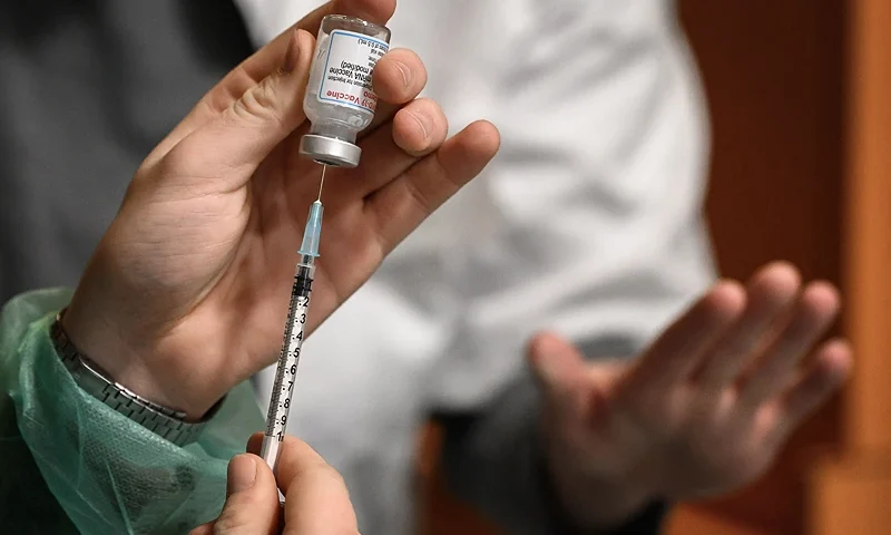 A Swiss soldier fills up a syringe with Moderna Covid-19 vaccine in Delemont, northern Switzerland, on December 14, 2021. - Switzerland hit by a new wave of infections, like much of Europe, has called army in to speed up vaccination. (Photo by Fabrice COFFRINI / AFP) (Photo by FABRICE COFFRINI/AFP via Getty Images)