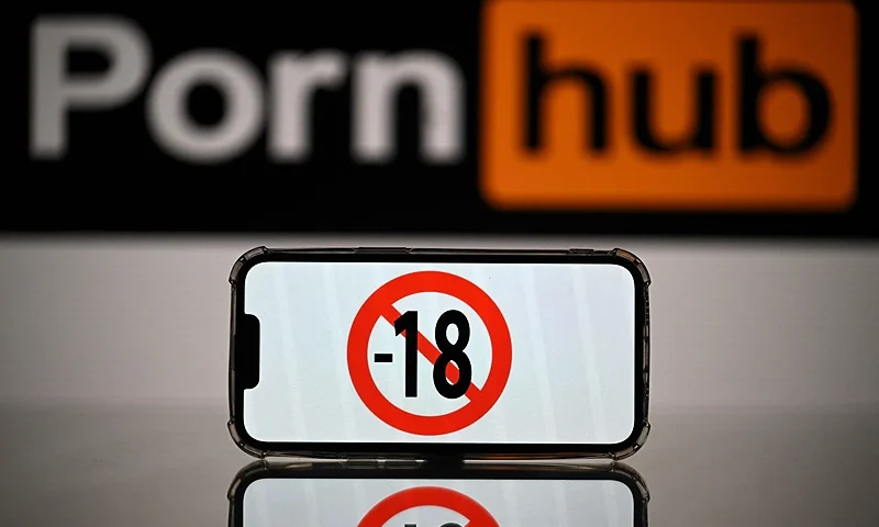 This photograph taken on May 24, 2022 in Toulouse shows screens displaying a minor child sign and the logo of the pornographic site Pornhub. - The judicial examination of Arcom request against porn sites has been postponed to one month, on May 24, 2022. Arcom media regulator requests five pornographic sites to be blocked as they are not preventing the exposure of minors to their content, and French telecom operators to block access to the pornographic sites. (Photo by Lionel BONAVENTURE / AFP) (Photo by LIONEL BONAVENTURE/AFP via Getty Images)