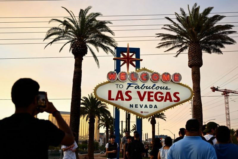 People take pictures with the Welcome To Fabulous Las Vegas sign under hazy orange skies as the sun sets in Las Vegas, Nevada on July 29, 2023. The National Weather Service said Saturday that the York Fire burning in the Mojave National Preserve is sending smoke into the Las Vegas Valley. (Photo by Patrick T. Fallon / AFP) (Photo by PATRICK T. FALLON/AFP via Getty Images)