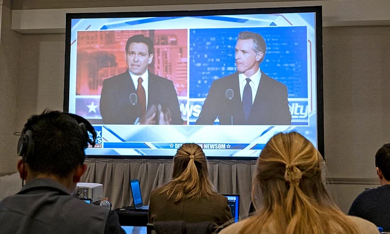 Florida Governor and Republican presidential hopeful Ron DeSantis (L) and California Governor Gavin Newsom (R) appear on screen from the press room during a debate held by Fox News, in Alpharetta, Georgia, on November 30, 2023. (Photo by Christian MONTERROSA / AFP) (Photo by CHRISTIAN MONTERROSA/AFP via Getty Images)