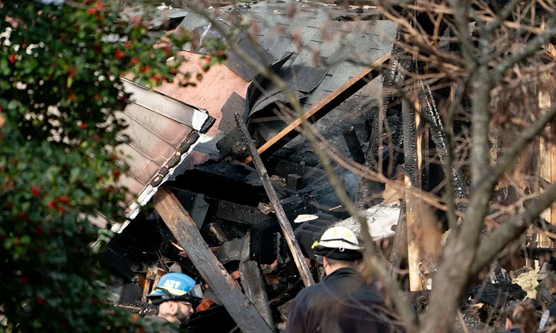 US-EXPLOSION-HOME Workers look at a home that exploded in Arlington, Virginia, on December 4 and rocked a neighborhood with a powerful blast, on December 5, 2023. Three police officers received minor injuries but were not taken to hospitals, the department said. Officials are unaware of anyone else who was hurt, they said at a news conference. (Photo by Stefani Reynolds / AFP) (Photo by STEFANI REYNOLDS/AFP via Getty Images)