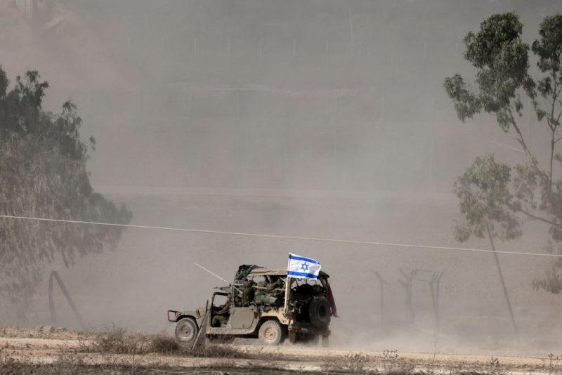 A picture taken in southern Israel near the border with the Gaza Strip on December 12, 2023, shows an Israeli army vehicle carrying soldiers into northern Gaza, amid continuing battles between Israel and the militant group Hamas. (Photo by Menahem KAHANA / AFP) (Photo by MENAHEM KAHANA/AFP via Getty Images)