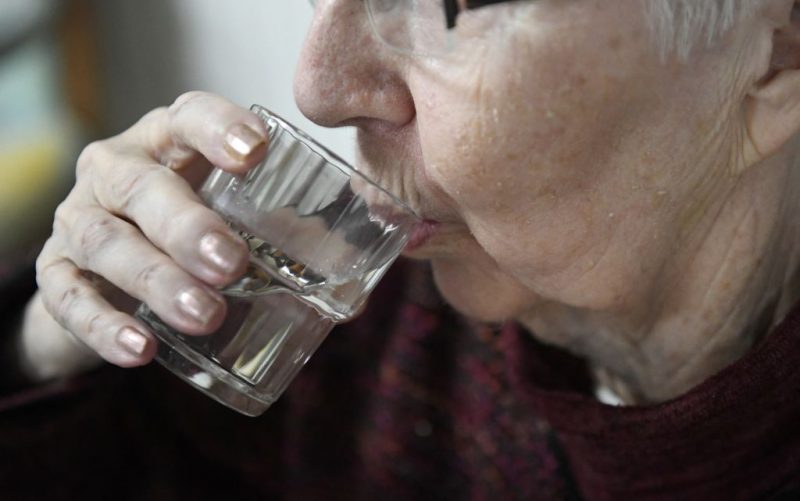 An old person drinks a glass of water in a retirement home on June 19, 2017 in Quimper, western France, as Meteo France has placed 16 departments on orange alert for heatwaves on June 19, 2017 in Nantes, western France. (Photo by Fred TANNEAU / AFP) (Photo by FRED TANNEAU/AFP via Getty Images)