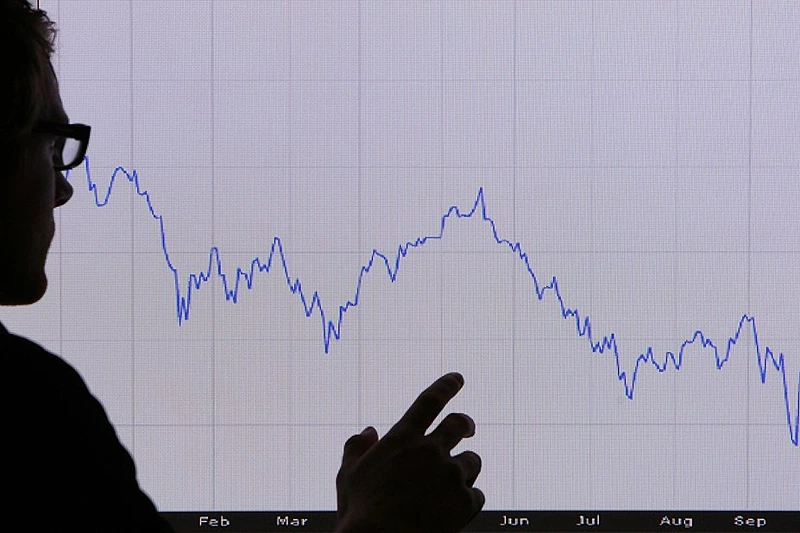 LONDON - OCTOBER 07: In this photo illustration, a man looks at a graph representing the 12 month decline of the FTSE 100 share index on October 7, 2008 in London. Financial markets are still suffering large losses as the global banking crisis continued. (Photo by Peter Macdiarmid/Getty Images)