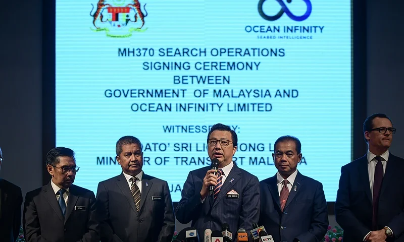 Malaysia's Transport Minister Liow Tiong Lai (C) speaks during a press conference as Director general of Malaysia's Civil Aviation Department Azharuddin Abdul Rahman (2nd L) and CEO of Ocean Infinity Limited Oliver Plunkett (R) listen after a signing ceremony to resume the search for missing Malaysia Airlines flight MH370 at the Malaysian federal administrative centre in Putrajaya, outside Kuala Lumpur on January 10, 2018. Malaysia signed a deal with an American firm on January 10 to resume the hunt for MH370 almost four years after the plane disappeared, with the company to receive up to $70 million if successful. / AFP PHOTO / MOHD RASFAN (Photo credit should read MOHD RASFAN/AFP via Getty Images)