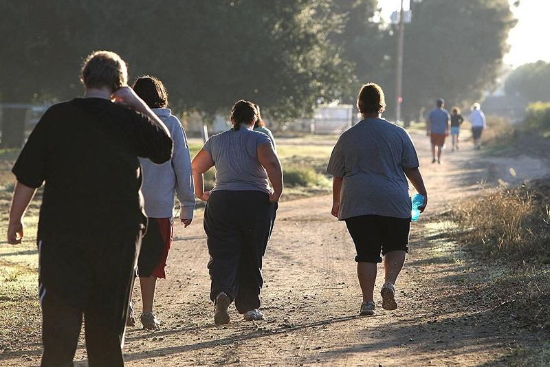 REEDLEY, CA - OCTOBER 19:  Seventeen year-old Marissa Hamilton (R) walks with friends during a morning walk at Wellspring Academy October 19, 2009 in Reedley, California. Struggling with her weight, seventeen year-old Marissa Hamilton enrolled at the Wellspring Academy, a special school that helps teens and college level students lose weight along with academic courses. When Marissa first started her semester at Wellspring she weighed in at 340 pounds and has since dropped over 40 pounds of weight in the first two months of the program. According to the Centers for Disease Control and Prevention, 16 percent of children in the US ages 6-19 years are overweight or obese, three times the amount since 1980.  (Photo by Justin Sullivan/Getty Images)