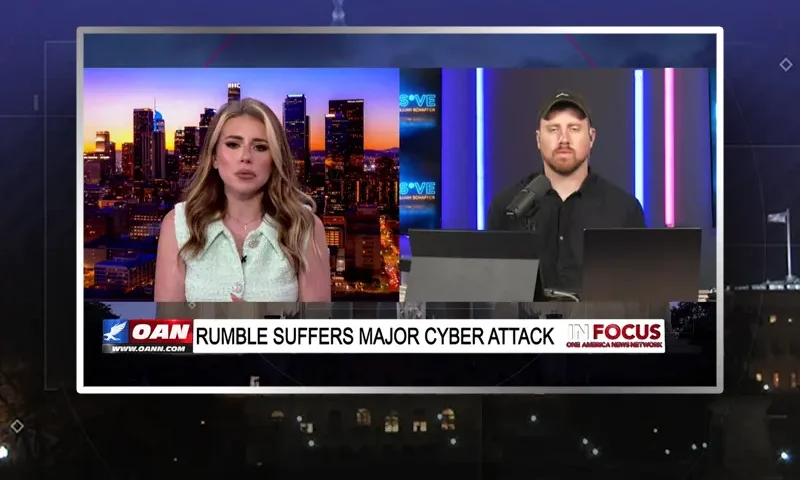 Video still from In Focus on One America News Network showing a split screen of the host on the left side, and on the right side is the guest, Elijah Schaffer.