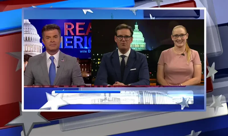 Video still from Real America on One America News Network showing a split screen of the host on the left side, and on the right side are guests Fletcher Gill and Kenna Hunter.
