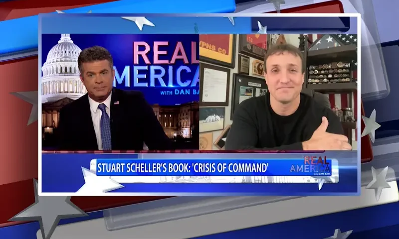 Video still from Real America on One America News Network showing a split screen of the host on the left side, and on the right side is the guest, Stuart Scheller.