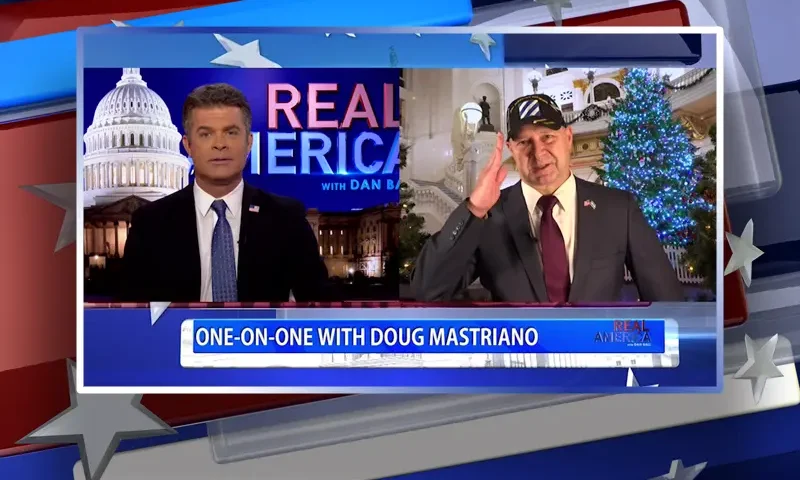 Video still from Real America on One America News Network showing a split screen of the host on the left side, and on the right side is the guest, Doug Mastriano.