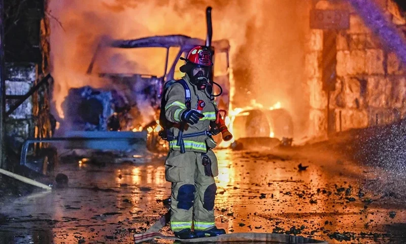A firefighter works the scene after a tractor trailer truck struck a railroad bridge and burst into flames in Glenville, N.Y., Thursday, Dec. 21, 2023. Authorities believed the truck contained gas containers. (Peter R. Barber/The Daily Gazette via AP)