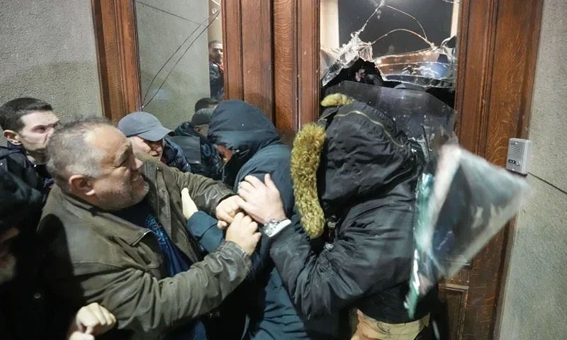 Opposition supporters attempt to enter the capital's city council building in protest of what election observers said were widespread vote irregularities during a general election last weekend in Belgrade, Serbia, Sunday, Dec. 24, 2023. The country's populist authorities have denied rigging the vote. President Aleksandar Vucic said Sunday that those claims were blatant "lies" promoted by the political opposition. (AP Photo/Darko Vojinovic)